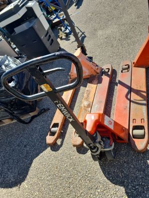 a fork lifter sitting on the ground next to a pile of trash