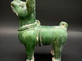 a green statue of a dog on a black background