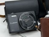 a camera and a brown bag on a white table