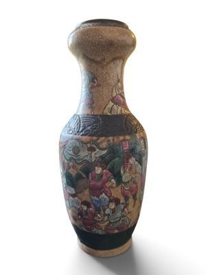 a vase with a painting on it sitting on a white surface