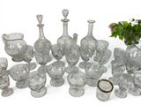 a lot of glass vases and glasses on the table