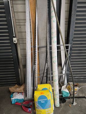 une pile de skis et de bâtons de ski devant la porte d'un garage