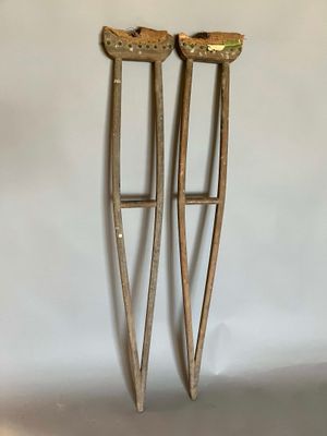 pair of antique cast iron crutts with wooden handles