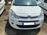 une petite voiture blanche garée sur un parking à côté d'une camionnette blanche