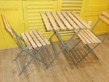 three folding chairs and a table in front of a yellow wall