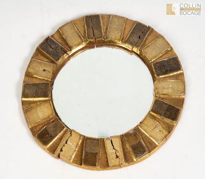 un miroir rond avec un cadre doré sur un fond blanc