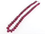 gros plan d'un collier de perles rouges sur fond blanc
