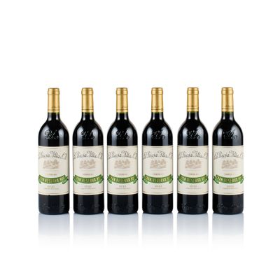 four bottles of wine are lined up on a white surface