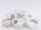 a pile of tea cups and saucers sitting on a table