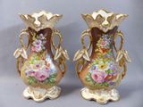deux vases avec des fleurs peintes dessus, posés sur une table