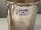 an old silver cup with a price tag on it sitting on a table