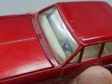 a red toy car that is being held up by a person