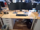 a desk with two monitors and a keyboard on it