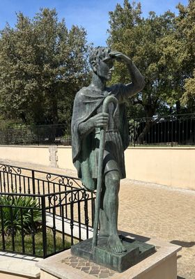 a statue of a man that is standing in front of a fence