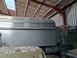 a military vehicle parked inside of a building with other military vehicles