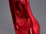 an image of a shiny red shoe on a gray surface