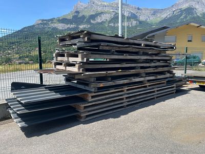 un gros tas de palettes empilées au bord de la route
