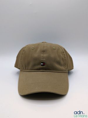 Le chapeau est de couleur beige et comporte un petit écusson sur le devant.