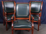 trois fauteuils en cuir vert et un fauteuil à structure en bois