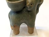 statue of an elephant with a bowl on its back on a white surface