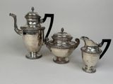 three pieces of silver tea and coffee set on a white surface