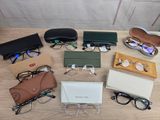 several pairs of glasses and glasses cases on a table