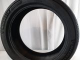 a close up of a tire on a white surface with a curtain in the background