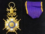 purple and gold medal with a purple ribbon and a gold star
