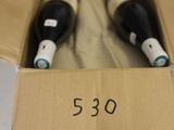 two bottles of wine in a cardboard box on a table
