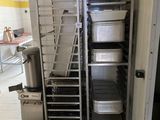 Plusieurs plateaux de nourriture sont empilés sur un chariot dans une cuisine
