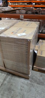 de nombreux cartons posés à même le sol dans l'entrepôt