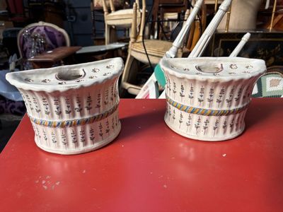 une paire de vases en céramique blancs et rouges posés sur une table rouge