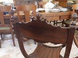 a wooden chair that is sitting in the middle of a room