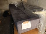 a couch that is wrapped in plastic and sitting on a table