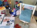 a pile of toys on a bed next to a stuffed animal
