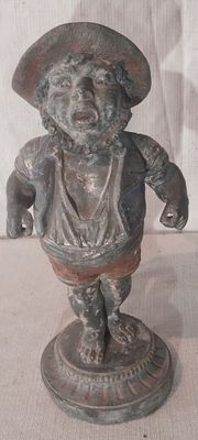 une statue représentant un homme coiffé d'un chapeau, posée sur un socle