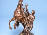 bronze statue of a man on a horse being pulled by a man on a horse