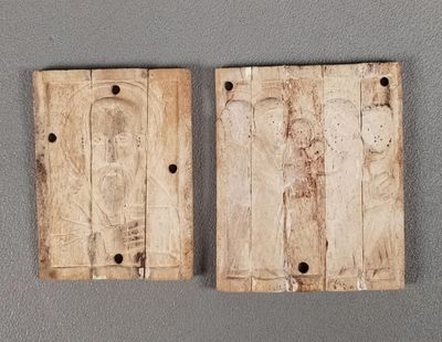 deux morceaux de bois percés de trous, posés sur une surface grise