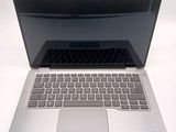 a silver laptop with a black keyboard on a white surface