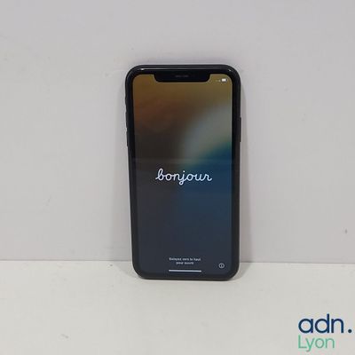 Un iPhone repose sur une surface blanche sur laquelle est inscrit le mot « bonjouie ».