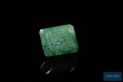 un gros plan d'une émeraude verte sur une surface noire