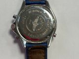 wrist watch on a white surface with a blue leather strap