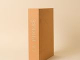 une image représentant un livre marron posé sur une surface blanche