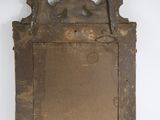 an old mirror hanging on the wall with a wooden frame