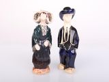 two figurines of a man and a woman standing next to each other