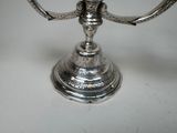 a silver candle holder on a white table