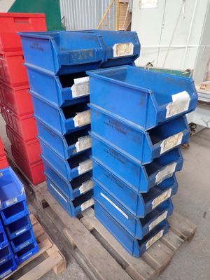 une pile de bacs bleus et rouges posée sur une palette