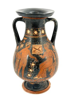 a black and orange vase on a stand with a white background