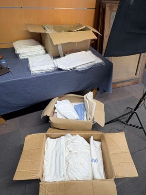 de nombreux cartons de vêtements posés par terre à côté d'un appareil photo