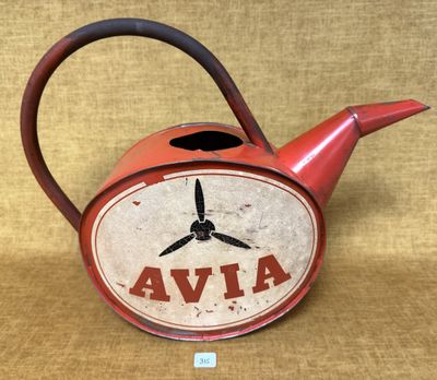 une vieille théière rouge ornée d'une horloge, posée sur une table